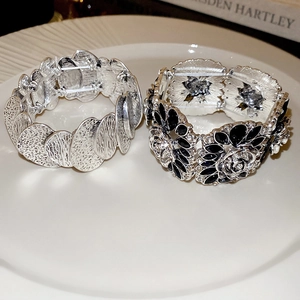 Detail view of vintage flower stretch bracelets with black stones and silver wavy texture