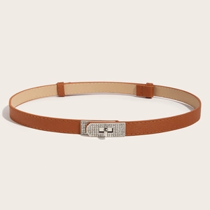 Detail of slim brown leather belt with sparkling rhinestone twist-lock metal buckle