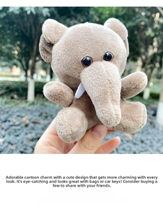 Close-up of a small light brown plush elephant keychain accessory with ivory details
