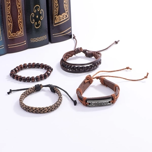 Détail d'un ensemble de 4 bracelets vintage en cuir avec perles de bois et plaque gravée