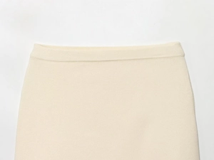Detail of high-density cream knit fabric showing soft texture and premium waist stitching
