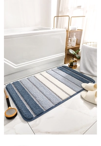 Détail du tapis de bain rayé bleu et blanc moelleux dans un décor de salle de bain moderne