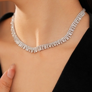 Dettaglio di una collana multistrato in argento con zirconi brillanti su modella