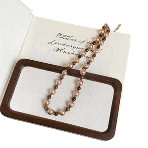 18K gold plated tiger eye stone beaded necklace with vintage pink pearls on a book