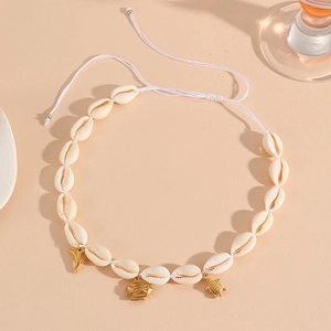Detail of shell necklace with golden dolphin, fish, and turtle charms on white cord