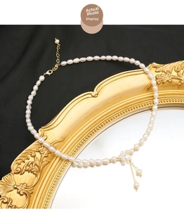 Collier de perles d'eau douce élégant avec pendentif fleuri sur un miroir doré