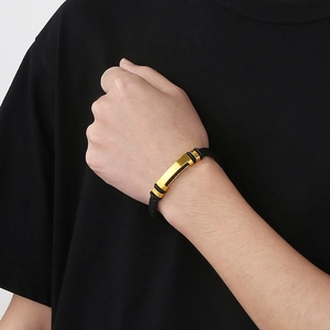 Braided leather bracelet with gold metal bar accent on wrist for men and women