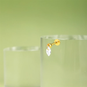 Macro detail of gold labret stud earring with marquise-cut crystal and flat back disc