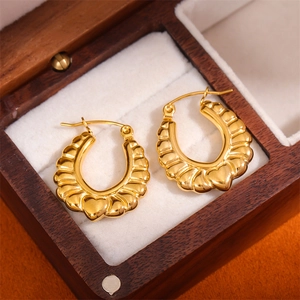 Elegant gold heart earrings with textured fan pleats on a luxury display box