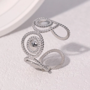 Macro detail of silver stainless steel open ring with twisted texture and hollow rings