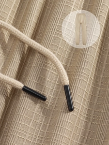 Detailed view of khaki waffle knit fabric and drawstring with black metal tips