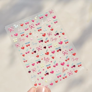 Detail of red cherry and pink bow nail stickers with crystal diamond 3D accents