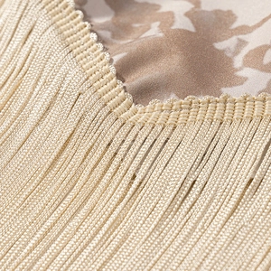 Macro shot of elegant champagne gold fringe tassel and floral jacquard fabric details