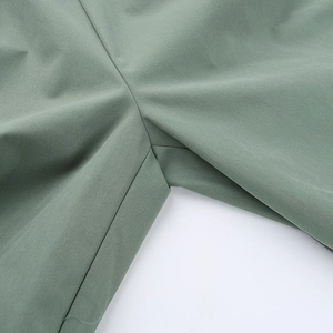 Dettaglio macro dei pantaloni cargo con tessuto verde e cuciture rinforzate sulla patta
