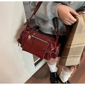 Détail d'un sac bandoulière vintage bordeaux en cuir lavé avec plusieurs fermetures éclair