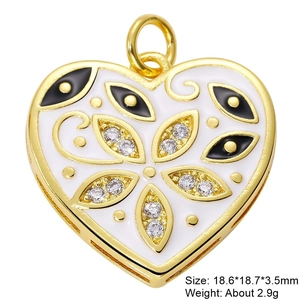 Macro detail of gold-plated heart pendant with white enamel and cubic zirconia inlay