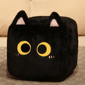 Close-up of square black plush cat toy with long fur and big yellow eyes on a soft mat