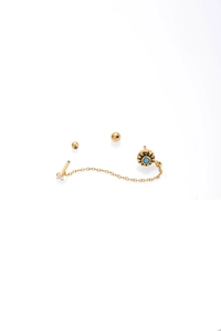 Macro detail of gold chain cartilage earring with blue sunburst and cubic zirconia