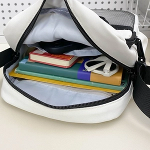 Minimalist white crossbody bag showing spacious interior compartments and simple design