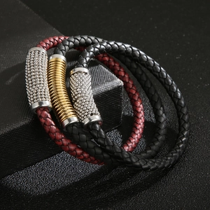 Macro shot of three-piece braided leather bracelets with gold and silver alloy accents