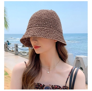 Close-up of the vintage brown woven straw sun hat material against a beach background