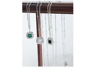 Detail of square glass stone pendants in emerald green, white, and black with rope textures