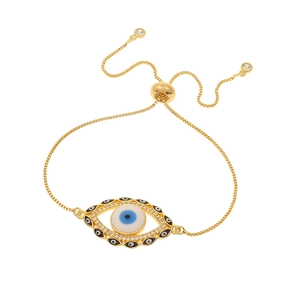 Detail of gold evil eye bracelet with blue enamel and sparkling rhinestone accents