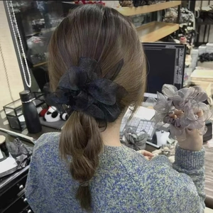 Dettaglio di elastici per capelli in organza con fiocco nero e viola polvere sui capelli