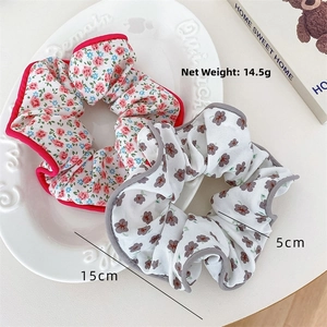Detail of floral scrunchies with 15cm outer diameter and 14.5g weight on a plate