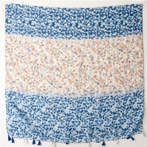 Detail of bohemian scarf with paisley print, leopard pattern and blue tassels