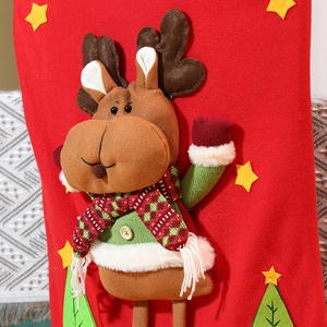 Detail of 3D reindeer doll with green sweater on red felt Christmas decoration sock
