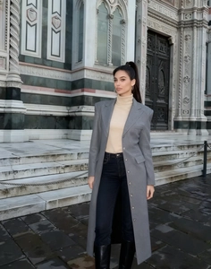 Dettaglio del cappotto lungo in lana grigio scuro con colletto a rever e linea elegante