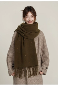 Detail of dark green scarf with colorful polka dots and fringe, soft warm texture