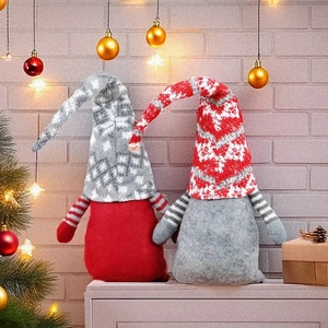 Lot de deux gnomes de Noël en tricot rouge et gris sur un fond intérieur festif