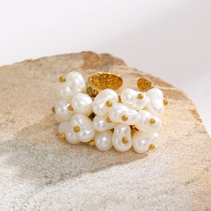 Detailed macro view of baroque pearl cluster and hammered gold metal texture on the ring