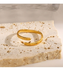 Detail of gold-plated stainless steel cuff bracelet with hammered texture on stone base