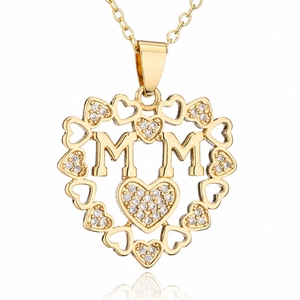 Macro shot of gold-plated heart pendant with MOM letters and shimmering inlaid crystals