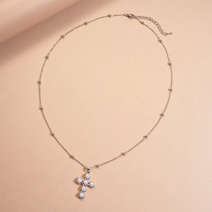 Elegant silver cross necklace with white pearls and sparkling zircons on pink background
