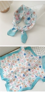 Detail view of light blue floral cotton linen scarf with elegant lace print and blue borders