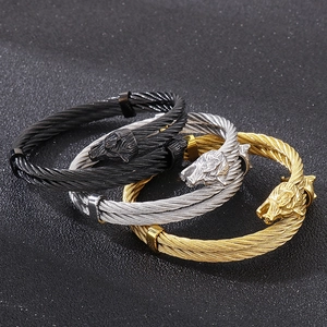 Rugged steel cable bracelets with double wolf heads in black, silver, and gold finishes