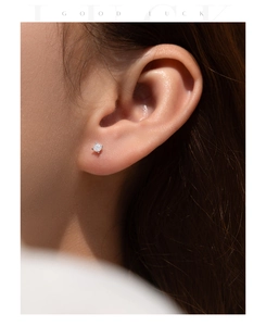 Close-up of minimalist S925 sterling silver 2 carat moissanite stud earring on ear