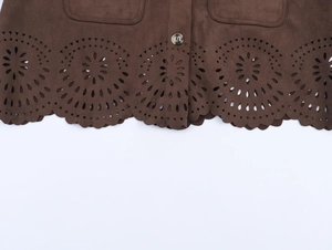 Detail of brown suede fabric featuring laser-cut floral patterns and a dark button closure