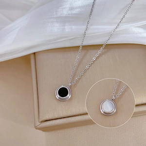 Detail of double-sided shell pendant necklace in black and white minimalist style