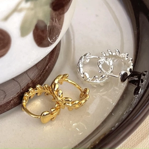 Détail des boucles d'oreilles feuilles en argent 925 doré et argenté sur céramique