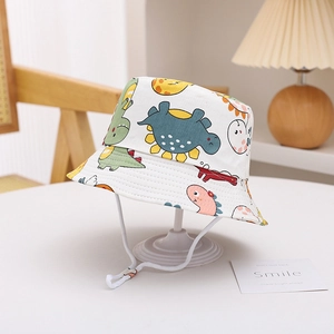 Close-up of kids dinosaur print bucket hat with adjustable white drawstring on desk