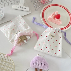 Detail of two-piece drawstring storage bags featuring red heart patterns on cotton fabric