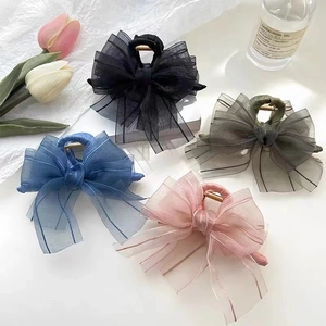 Elegant mesh bow hair claws in black, blue, pink, and green on a decorative background