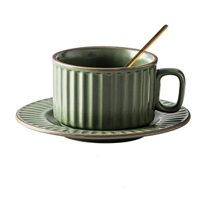 Detail of matte dark green ceramic coffee cup set with vertical stripes and golden spoon