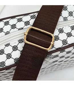 Close-up of adjustable brown nylon strap and gold metal buckle on white crossbody bag