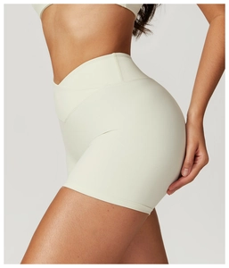 Détail du short de yoga à taille haute montrant la ceinture croisée en V et le tissu crème